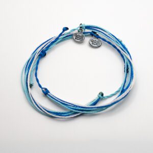 A blue and white string bracelet with a silver charm.