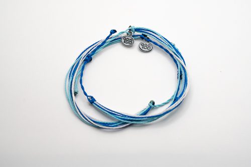 A blue and white string bracelet with a silver charm.