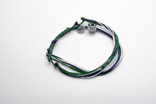 A bracelet with three different colors of string.