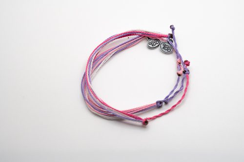 A bracelet with two different colors of string.