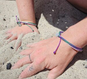 A person with tattoos on their hands and bracelets.